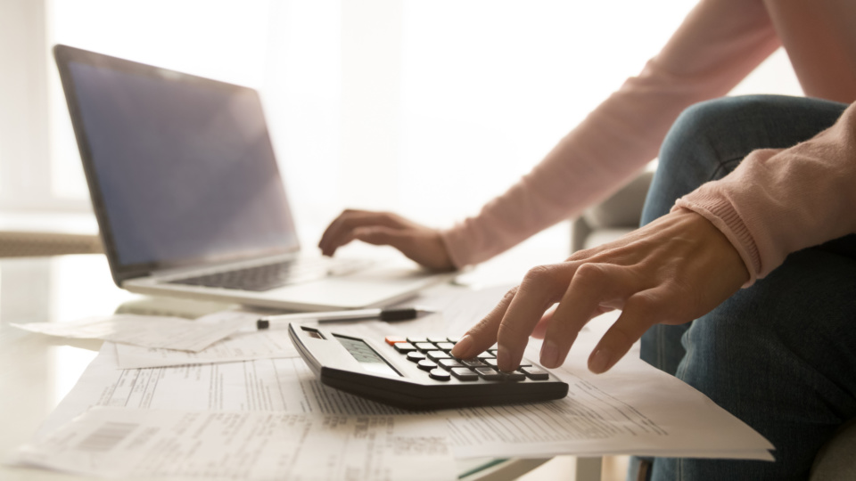 Close up of woman managing home utility bills 1173666081 2313x1301