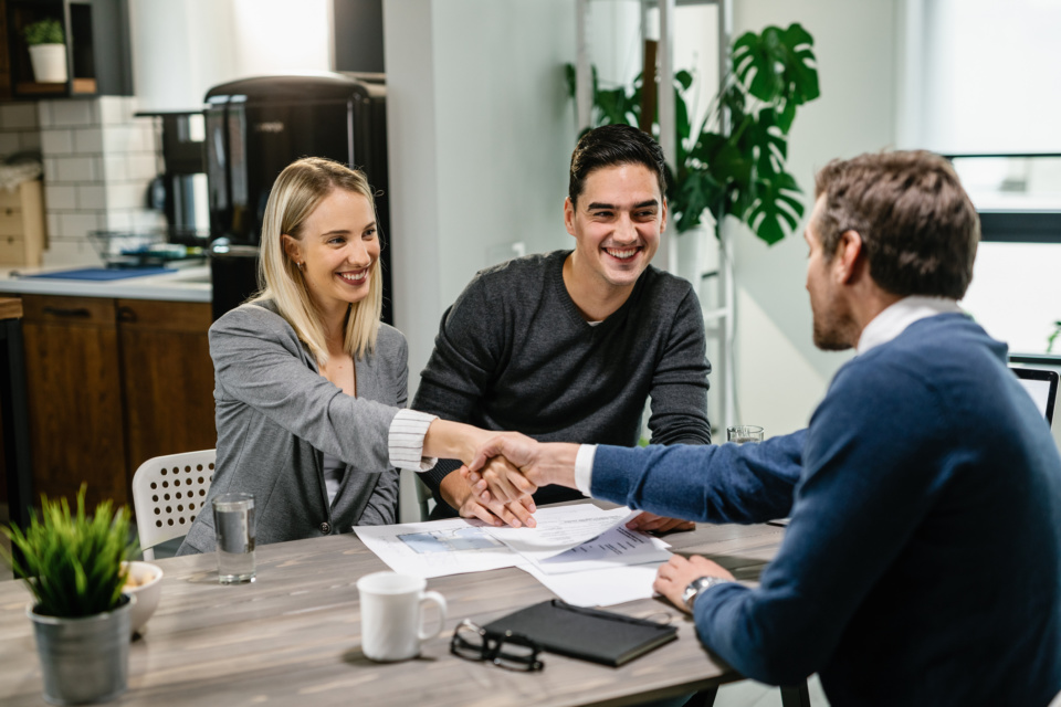 Happy couple making an agreement with real estate agent during the meeting 1157131798 2125x1416