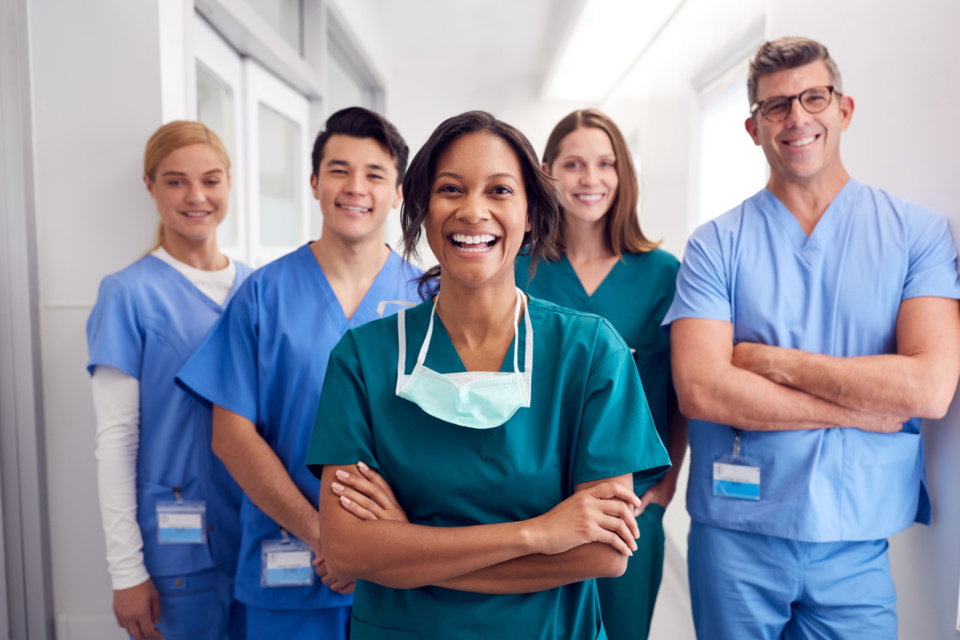 Portrait Of Laughing Multi Cultural Medical Team Standing In Hospital Corridor 1204001706 3869x2579