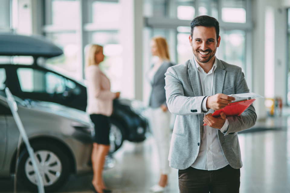 Successful businessman in a car dealership sale of vehicles to customers 1172428955 2125x1416